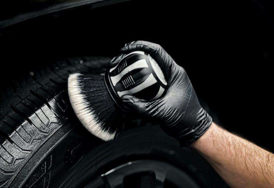 Gloved hand scrubbing a tire with a soft brush